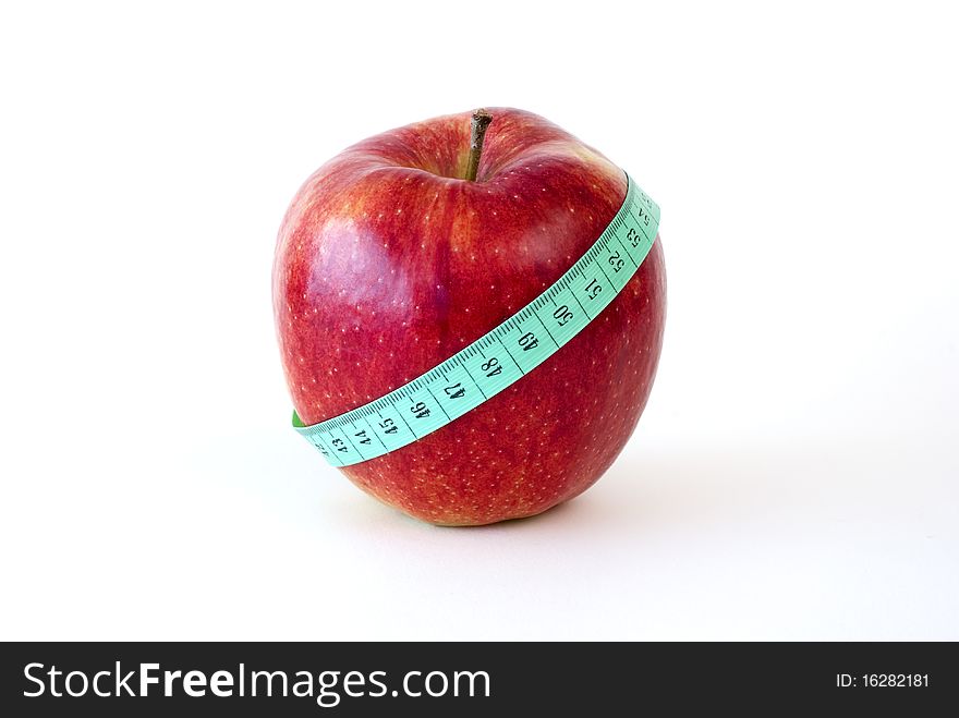 Fresh red apple wrapped up with the tape measure on the white background