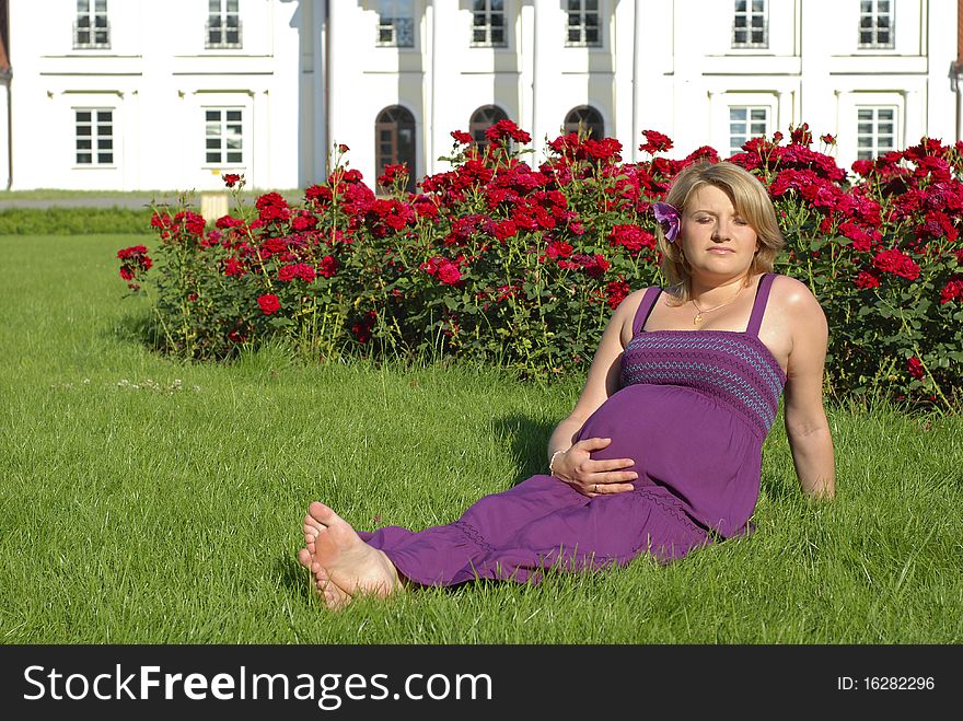 Pregnant woman in the garden in front of the palace