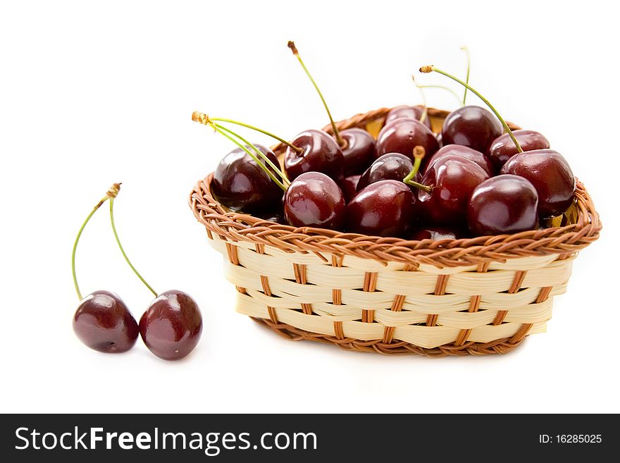 Juicy cherries in wicker bowl isolated on white