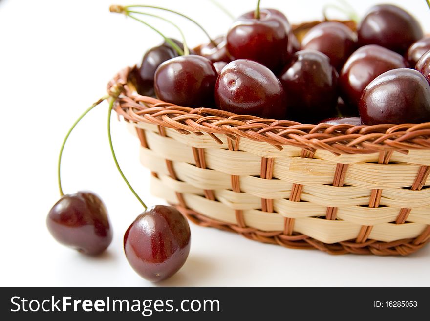 Close-up of ripe juicy cherries in wicker bowl. Close-up of ripe juicy cherries in wicker bowl