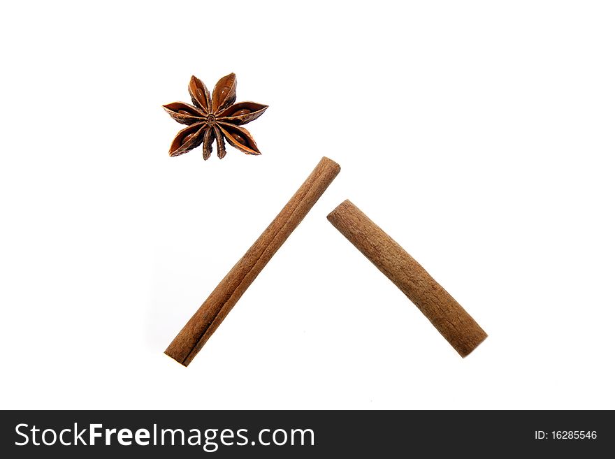 Anise stars and cinnamon sticks isolated on white arranged as a house and star. Christmas (Bethlehem) symbol