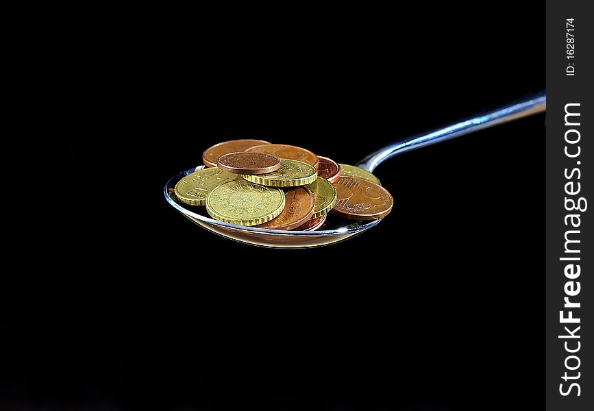 A spoon with coins, eat money