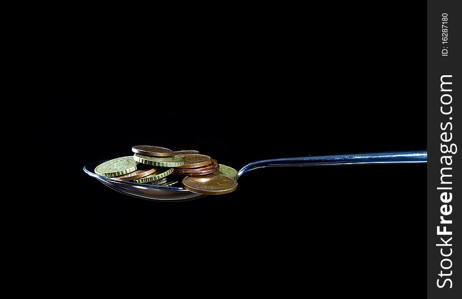 A spoon with coins, eat money