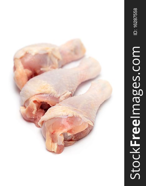 Close up of three raw chicken drumsticks isolated on white background.