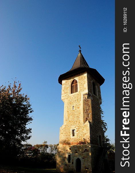 Exterior of monastery tower and trees in fall season