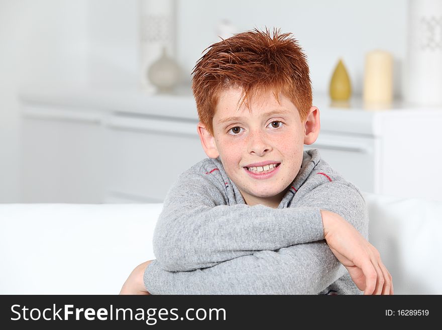 Young boy sitting in sofa with arms crossed. Young boy sitting in sofa with arms crossed