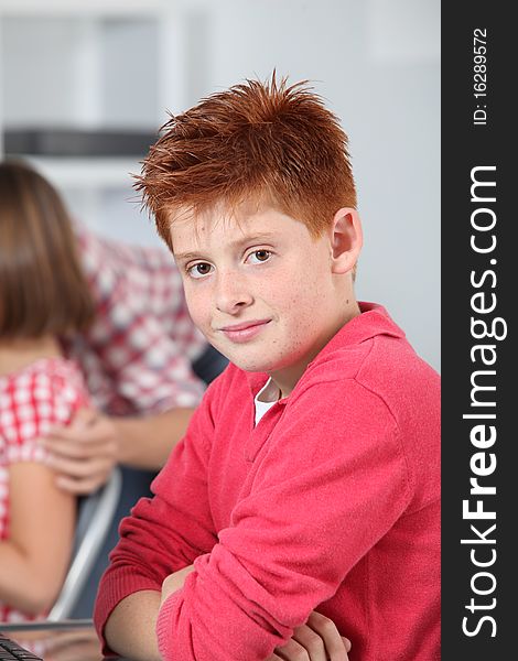Young red-haired boy in classroom. Young red-haired boy in classroom