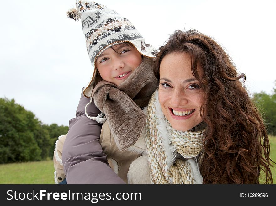 Woman Giving Piggyback Ride To Child