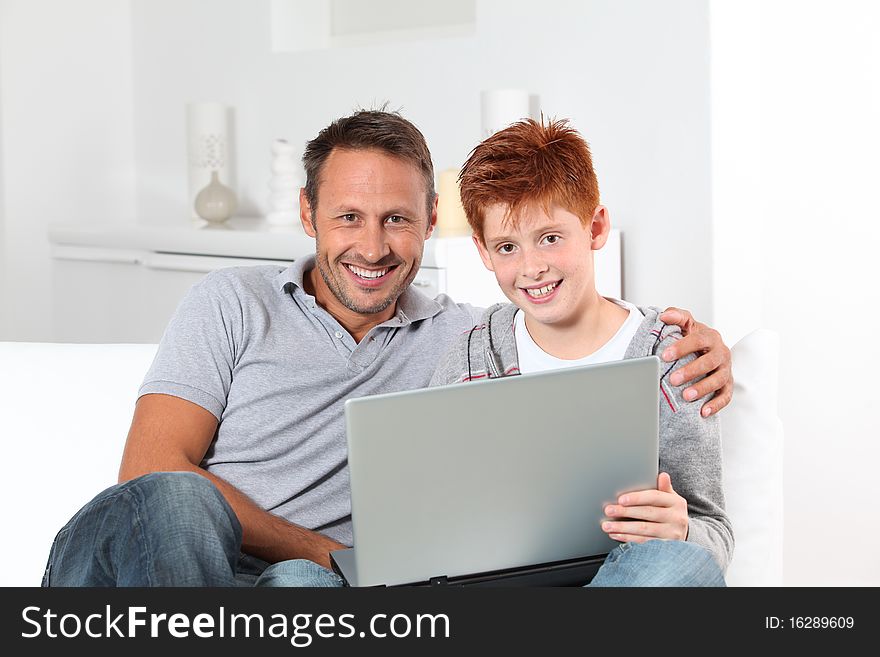 Man and child at home with laptop computer. Man and child at home with laptop computer