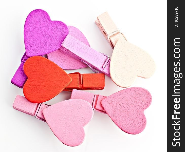 Pegs with a heart on a white background, macro photo. Pegs with a heart on a white background, macro photo