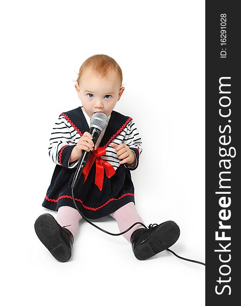 Sweet one year old baby girl with blue eyes singing with a microphone in her hand isolated on a white background. Sweet one year old baby girl with blue eyes singing with a microphone in her hand isolated on a white background