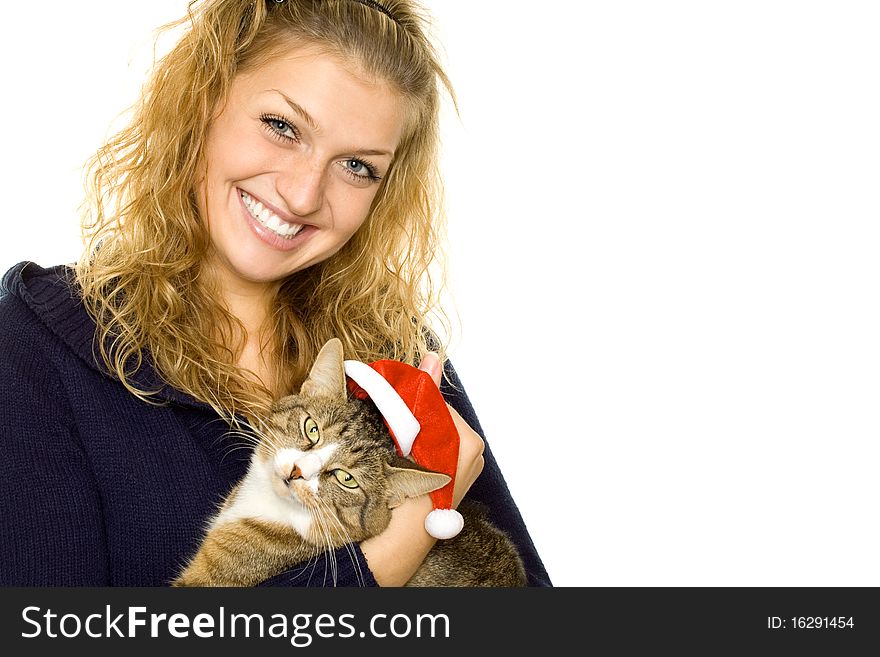 Beautiful girl in a sweater keeps on hand a cat which is wearing Christmas hat of Santa Claus. Isolated on white background. Beautiful girl in a sweater keeps on hand a cat which is wearing Christmas hat of Santa Claus. Isolated on white background