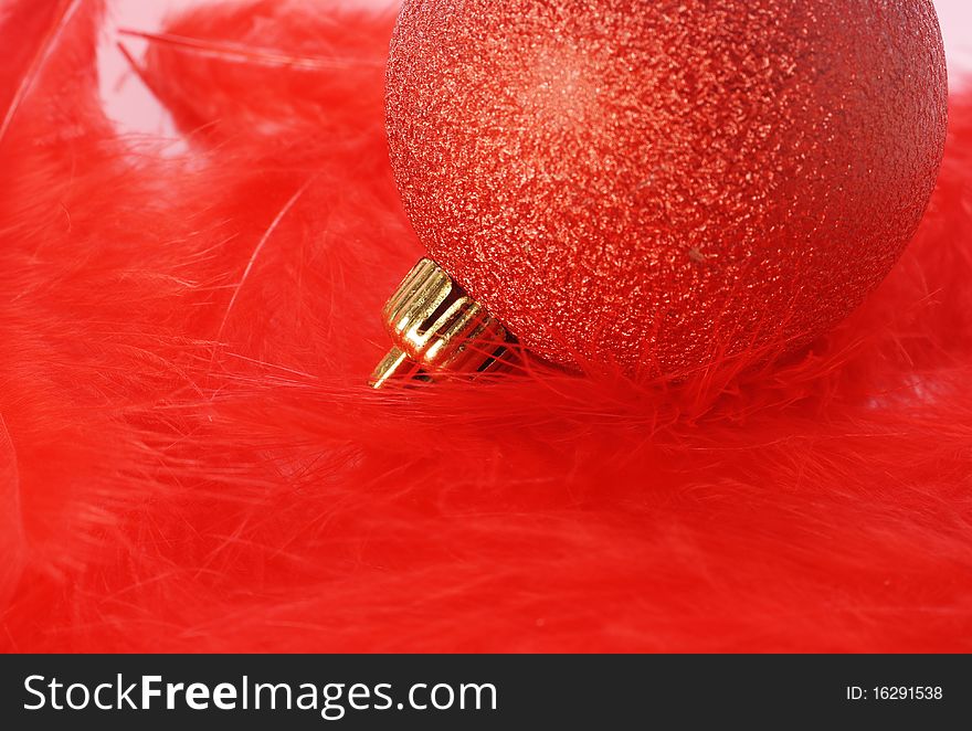 Red christmas bulb on red fluffy feathers