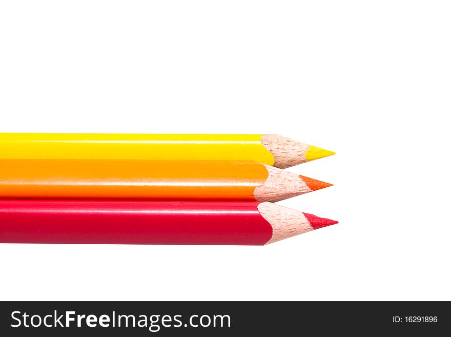 Three colored pencils in a row, orange,red,yellow