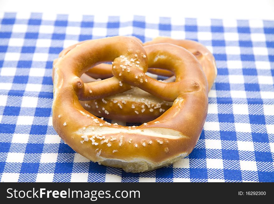Baked foods pretzel on blue white table cloth