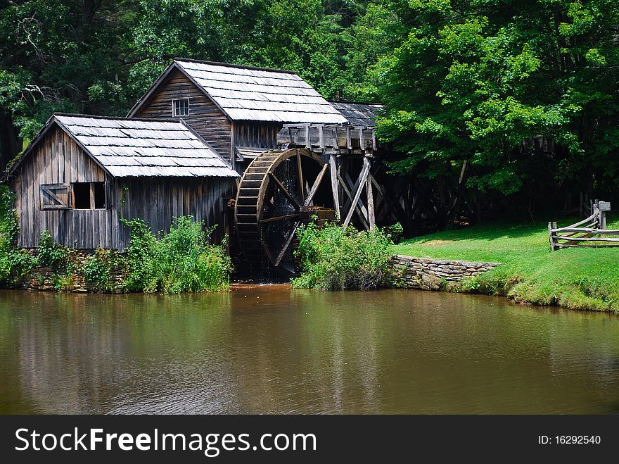 Wooden water mill with stream and green trees. Wooden water mill with stream and green trees