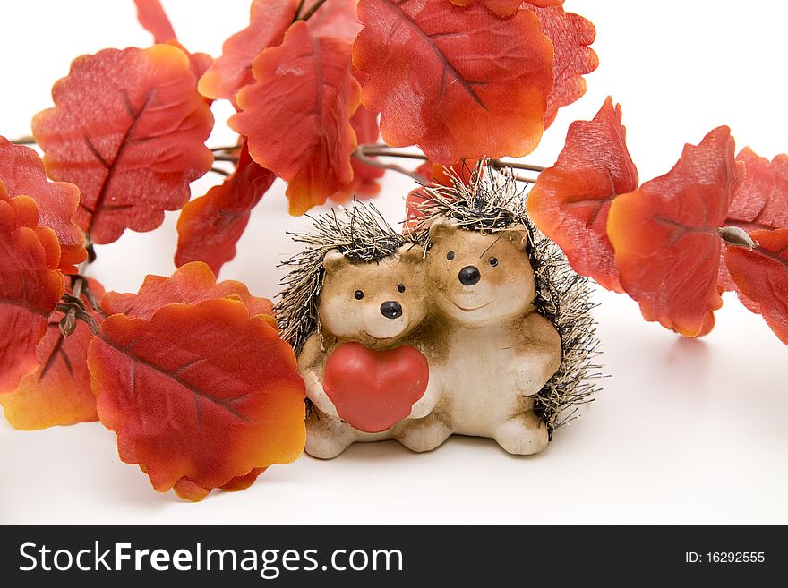 Hedgehog pair with heart under leaves