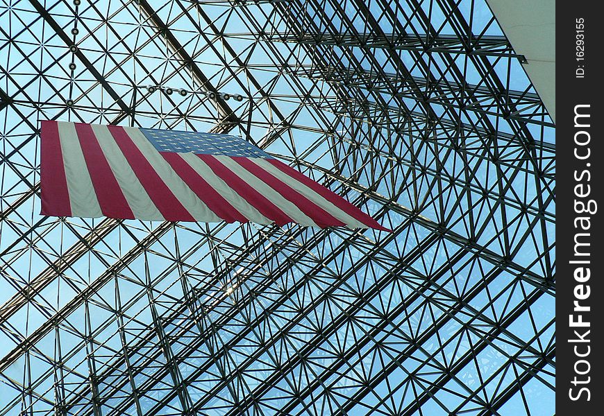 Metal structure of a modern building with clouds in the background and American flag. Metal structure of a modern building with clouds in the background and American flag