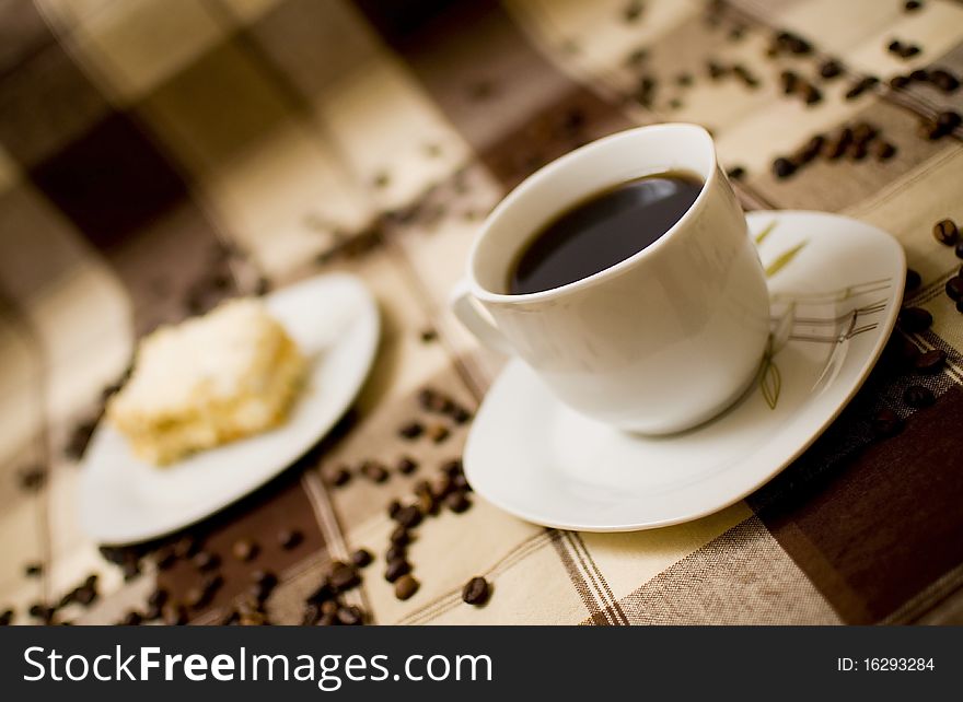 Coffee cup and cake on table, cake in blurred background. Coffee cup and cake on table, cake in blurred background
