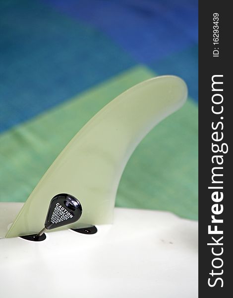 A Surf board fin and a Key which is used to tighten the bolts to keep the Fin in place. A Surf board fin and a Key which is used to tighten the bolts to keep the Fin in place.