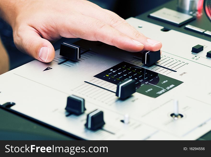 Hand of a disc jockey on the professional mixing controller. Hand of a disc jockey on the professional mixing controller