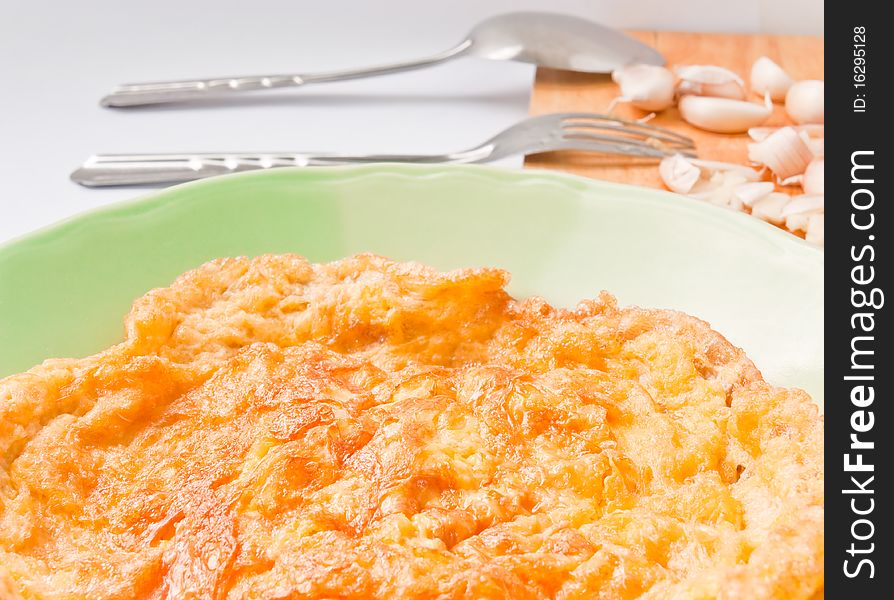 Omelet in a green dish on white background.