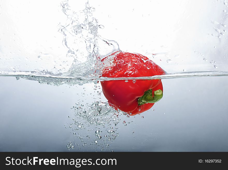 Fresh Red Bell Pepper splashing into water
