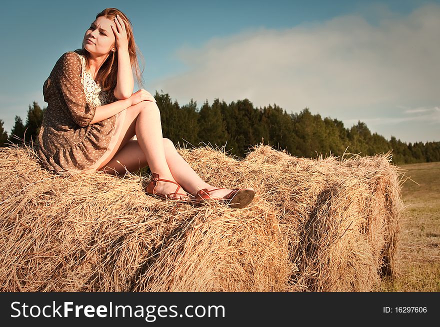 Young girl sitting on the field stack. Young girl sitting on the field stack