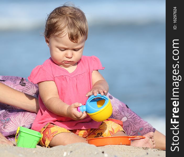 Girl playing toys in the sand