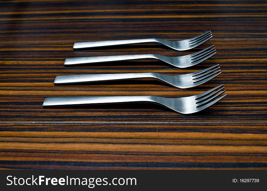 Blue Aluminum forks against the brown wood table. Blue Aluminum forks against the brown wood table