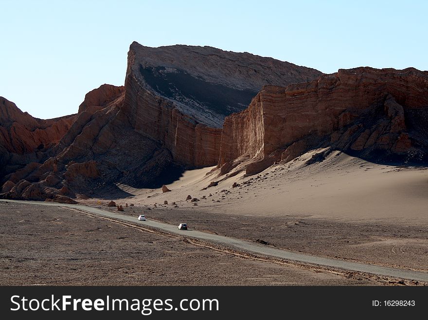 Rocky formation at Atacama Desert, in Chile, a region called Valle de la Luna (Moon Valley), with cars passing by. Rocky formation at Atacama Desert, in Chile, a region called Valle de la Luna (Moon Valley), with cars passing by.