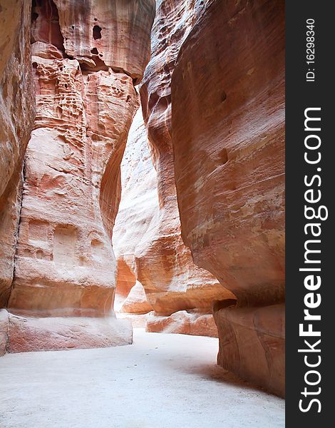 The Siq, narrow gorge, which resulted from the natural splitting of the mountain, leads into an ancient city of Petra, Jordan. The Siq, narrow gorge, which resulted from the natural splitting of the mountain, leads into an ancient city of Petra, Jordan