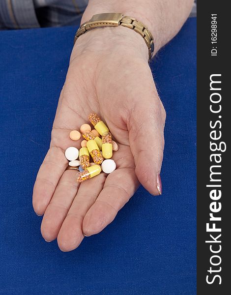 Elderly woman holds pills in her hand. Elderly woman holds pills in her hand.