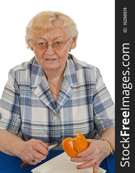 Elderly woman peeling an orange - isolated on white background. Elderly woman peeling an orange - isolated on white background