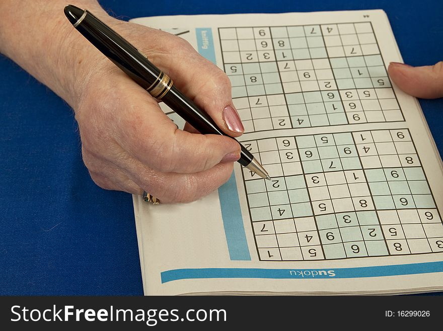 Elderly woman doing sudoku - isolated on white background. Elderly woman doing sudoku - isolated on white background