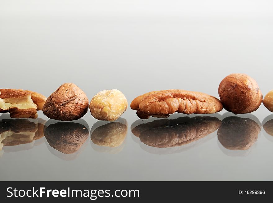 Macro closeup of a pile an arrangement of raw nuts. These are hazelnuts, chestnuts, filberts, peanuts, and pecans. Macro closeup of a pile an arrangement of raw nuts. These are hazelnuts, chestnuts, filberts, peanuts, and pecans.