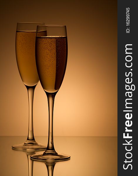 A glass of champagne, isolated on a yellow  background.