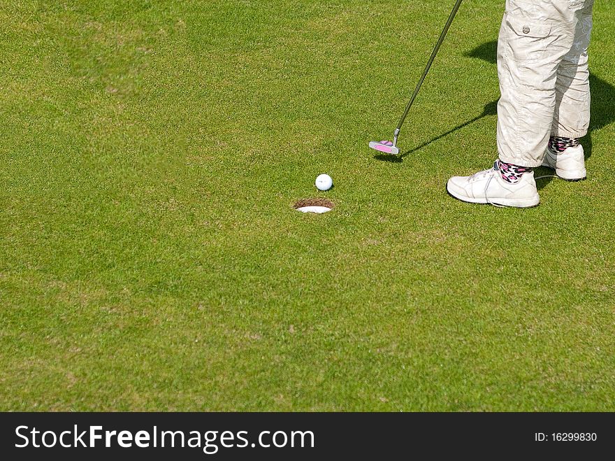 Golf ball on lip of cup of lovely beautiful golf course