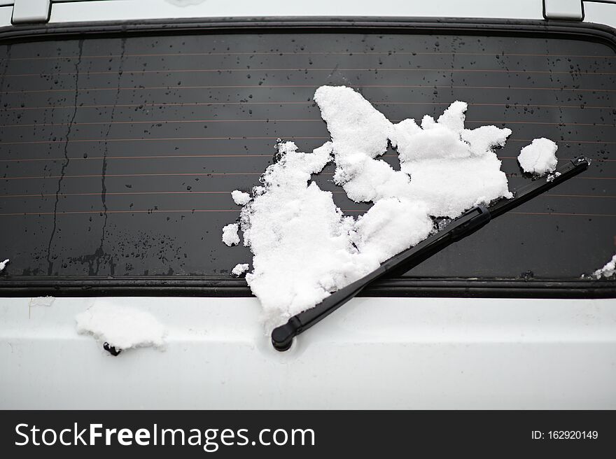 Cold winter weather concept of car trunk with window and wiper covered with white snow. Cold winter weather concept of car trunk with window and wiper covered with white snow