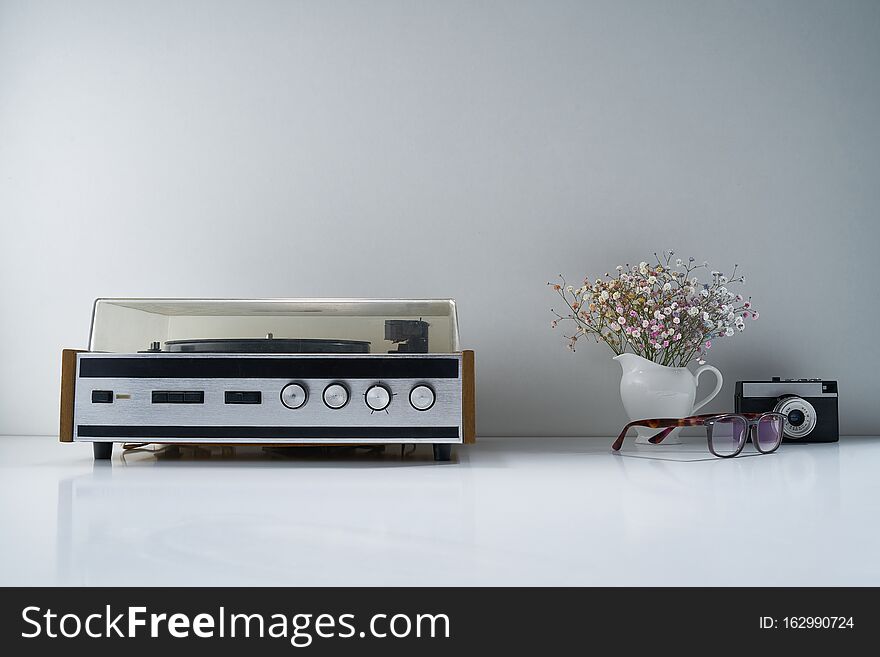 Composition with retro stereo radio and other vintage things with a gentle bouquet of flowers on a light gray background