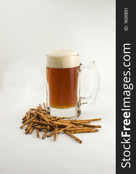 A mug of frosty beer and pretzels