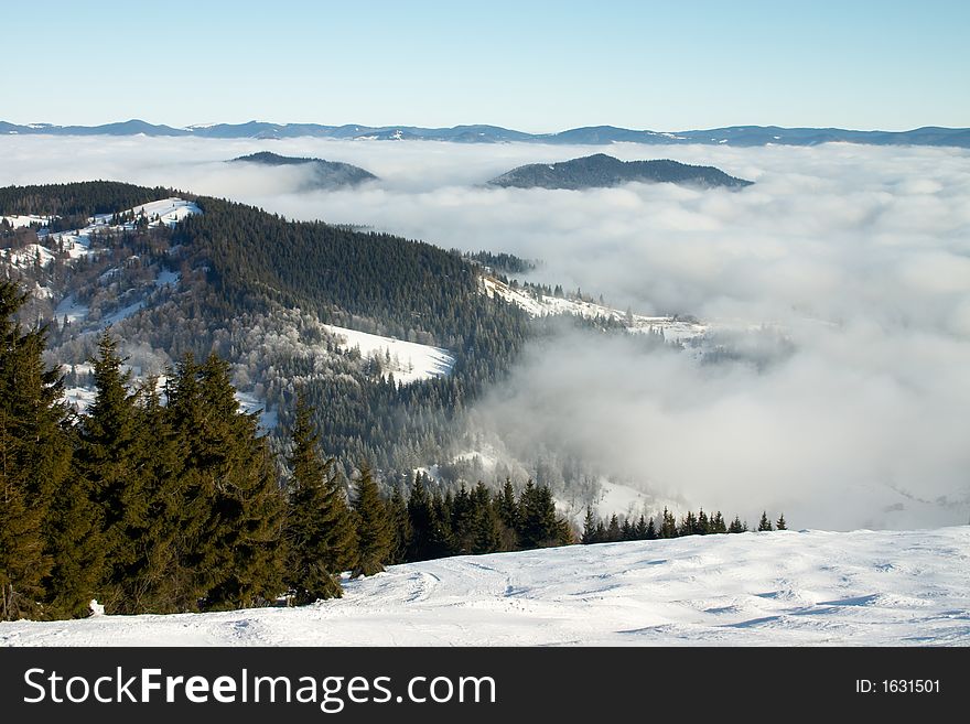 Winter landscape with mountains under white clods