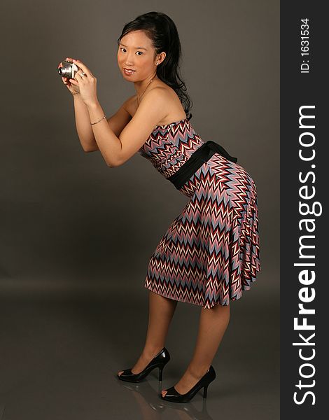 Asian woman in dress holding a camera. Asian woman in dress holding a camera