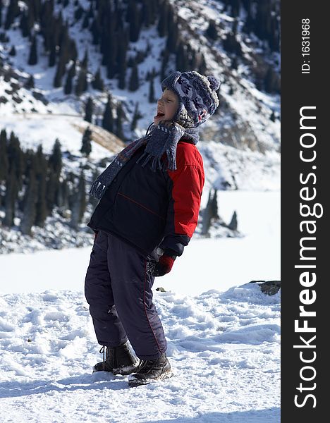 Laughing boy in winter mountain