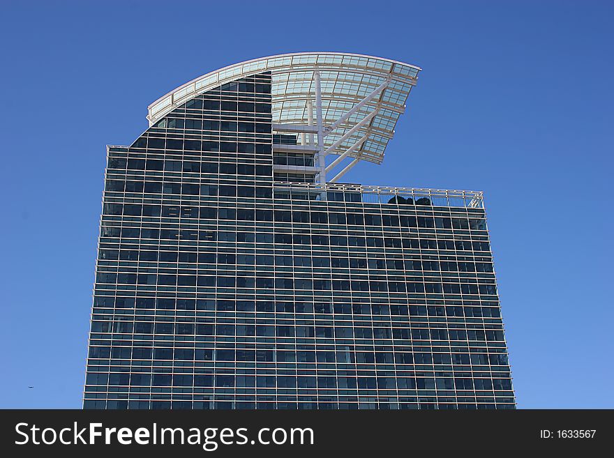 Modern Blue Glass building with curved roof against sky