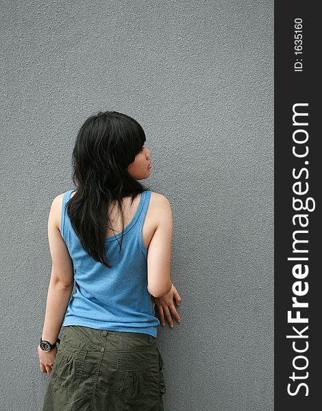 Asian girl touching a wall leaning close. Asian girl touching a wall leaning close