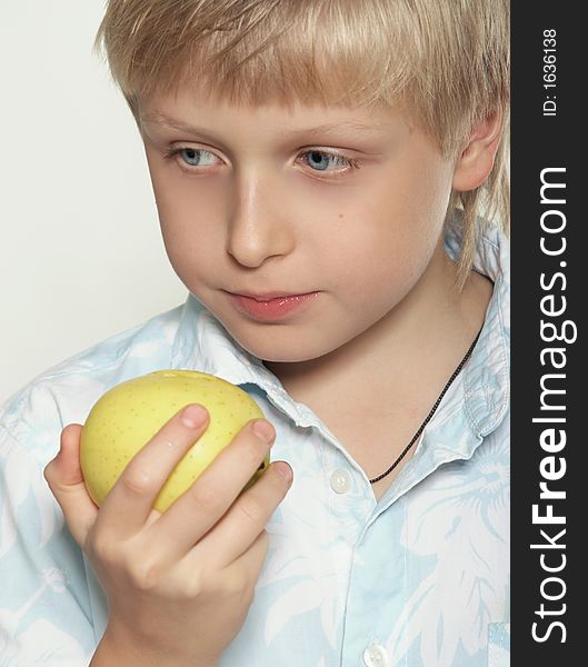 An eleven-year boy eats an apple. On white background. An eleven-year boy eats an apple. On white background.