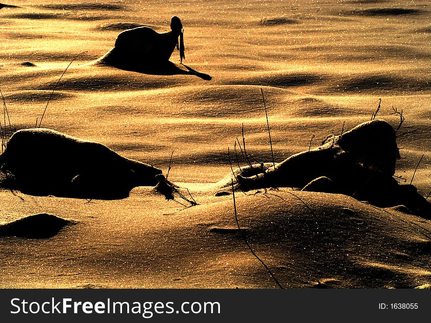 A Harvested Corn Field Covered With Snow At Sunset