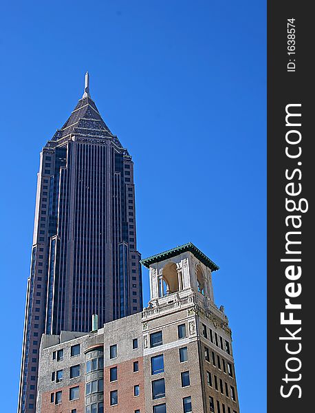 A modern skyscraper with old hotel building in foreground and sky in background. A modern skyscraper with old hotel building in foreground and sky in background