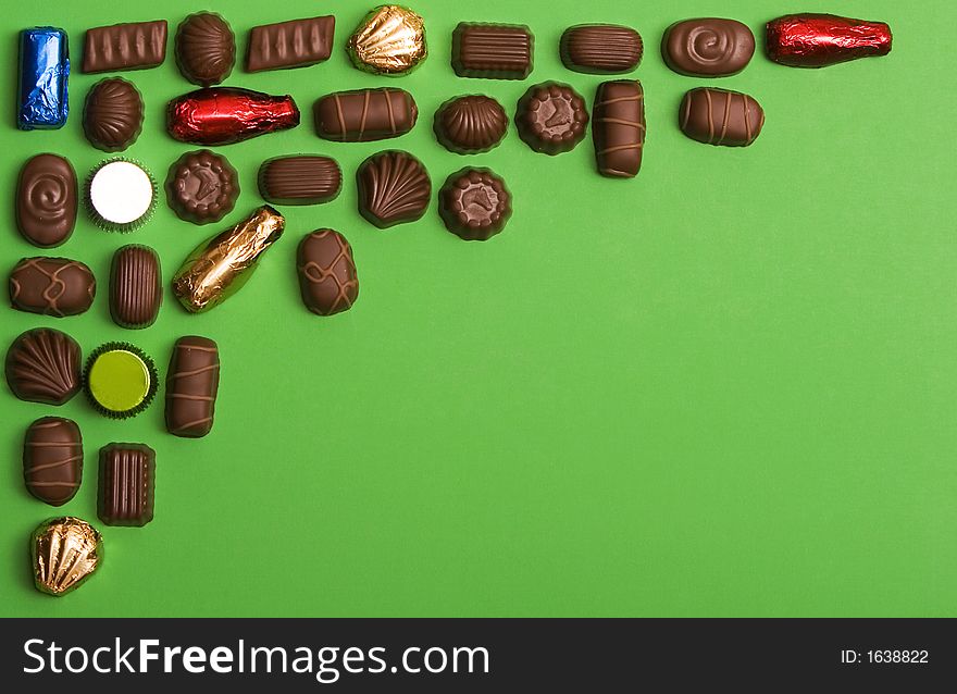 Fine chocolate on green background , forming a frame for designs. Fine chocolate on green background , forming a frame for designs